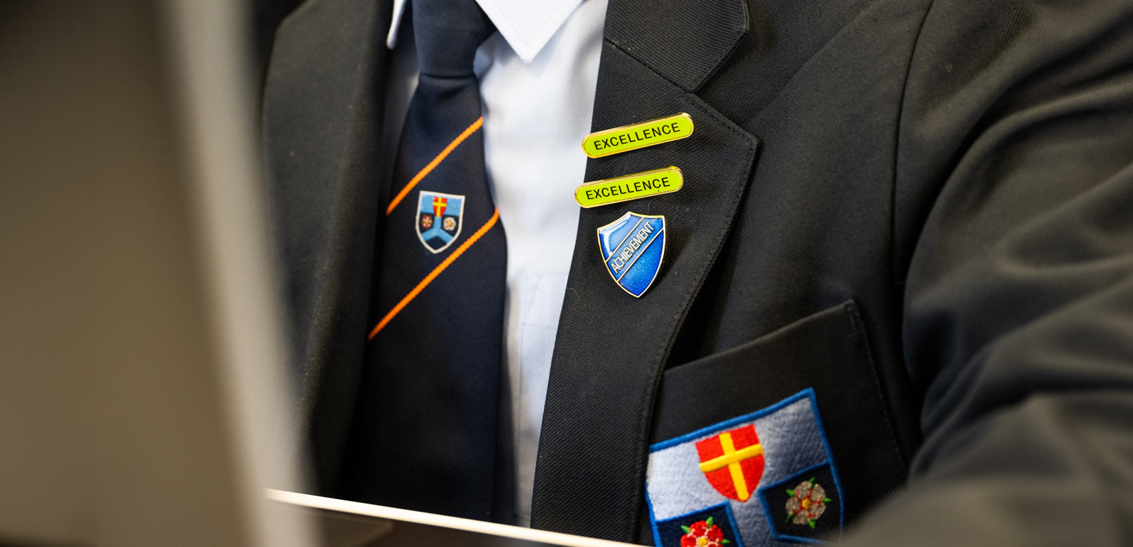 close up of students blazer and tie with prefect badges